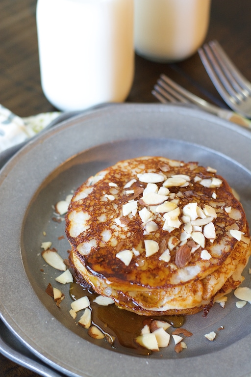 A stack of banana buttermilk pancakes on a metal plate. 