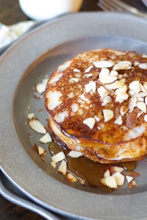 A stack of banana buttermilk pancakes on a metal plate. 