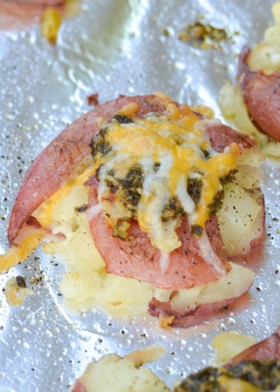 Combine four simple ingredients to make crispy, crunchy smashed potatoes! These smashed potatoes are tender on the inside, crispy on the outside and smothered with pesto and cheese for the perfect easy side dish