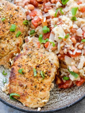 This One-Pan Pork Chops and Rice is loaded with tender rice, black eyed peas and Cajun pork chops. This easy dinner recipe is quick, inexpensive, and easy!