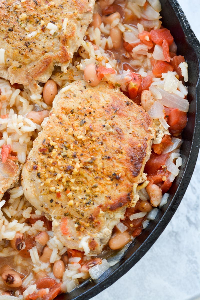 overhead view of tender pork chops and rice in a skillet 
