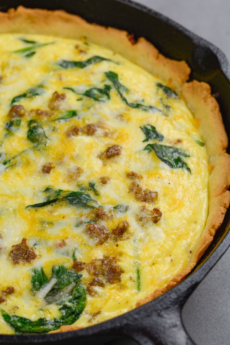 Close up of a keto spinach sausage quiche in a cast iron skillet 