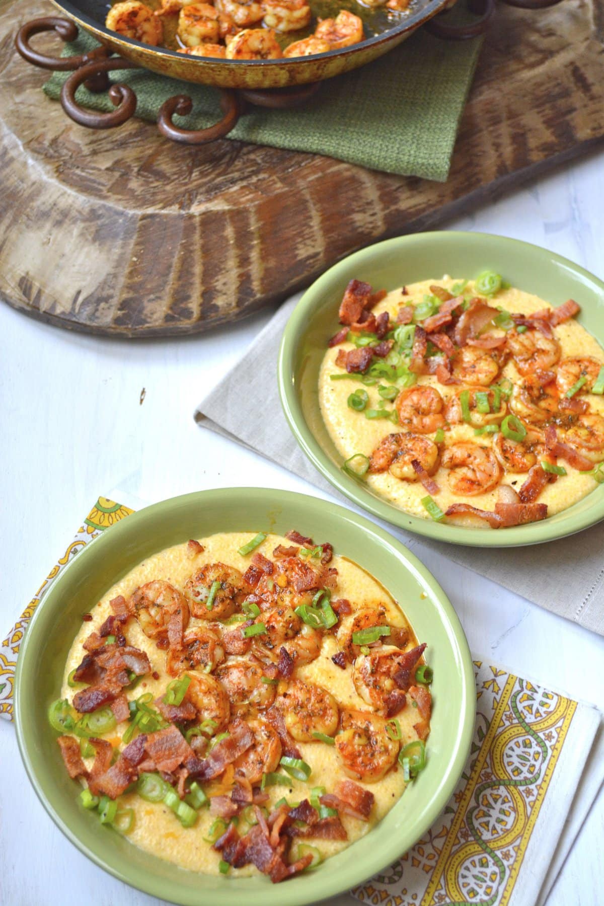 Easy Shrimp and Creamy Cheesy Grits! The ultimate southern meal! Cheesy grits, spicy shrimp, crispy bacon and fresh green onions make the ultimate comfort food!