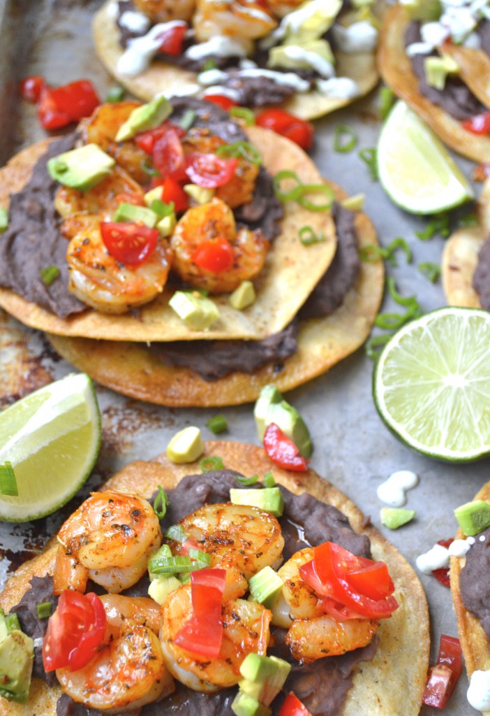 Closeup of two loaded shrimp tostadas on homemade shells. 