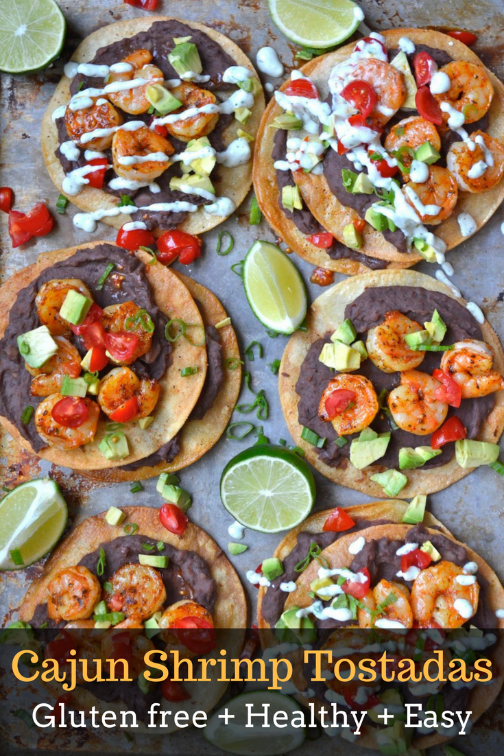 Overhead view of six homemade shrimp tostadas loaded with toppings. 