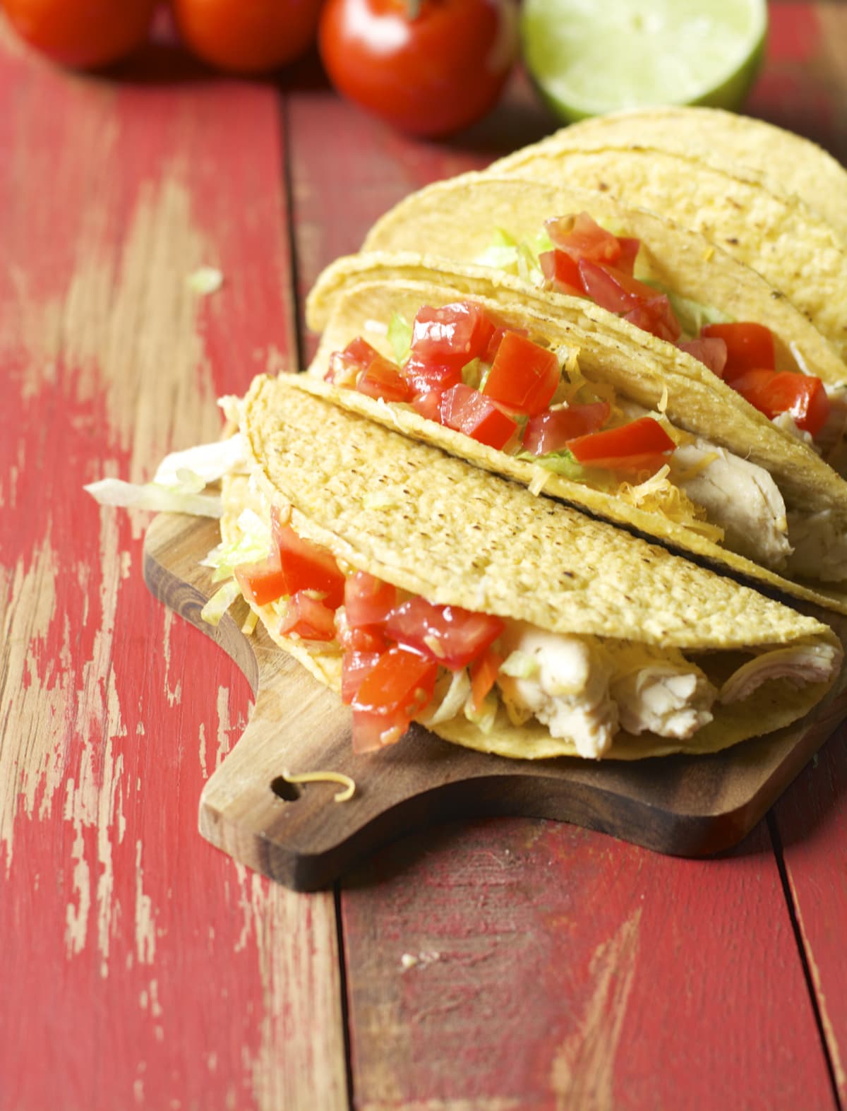 four slow cooker chicken tacos on a wood serving platter 