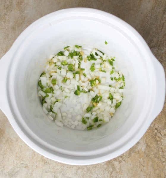 overhead view of diced onion and jalapeno in a crockpot 