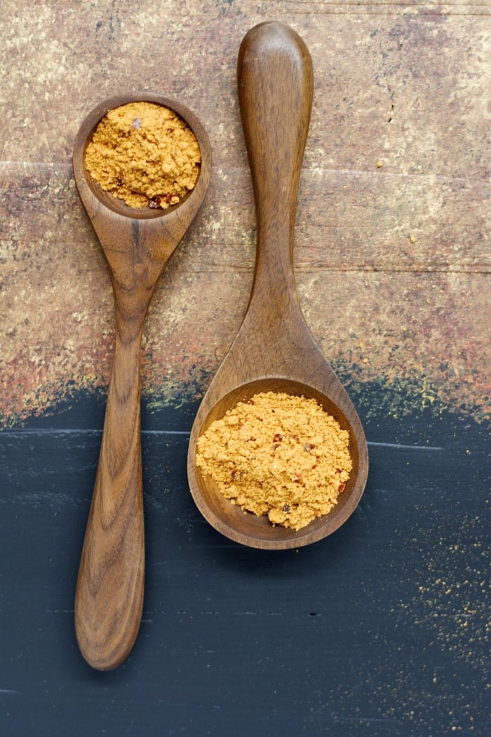 overhead view of two wooden spoons holding homemade taco seasoning