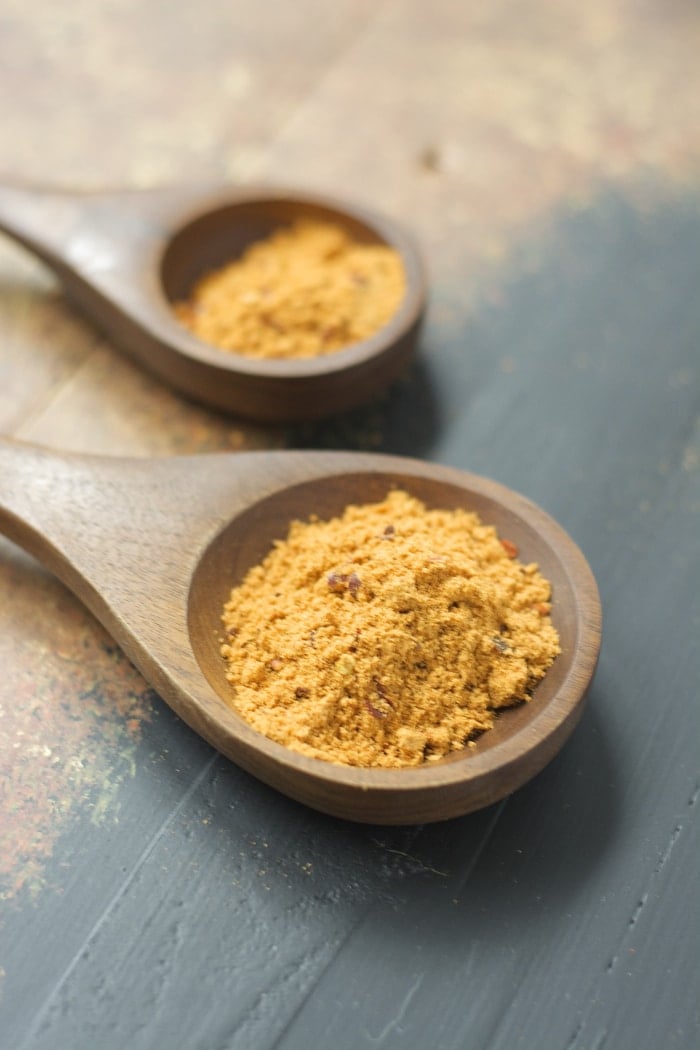 side view of two wooden spoons holding homemade taco seasoning