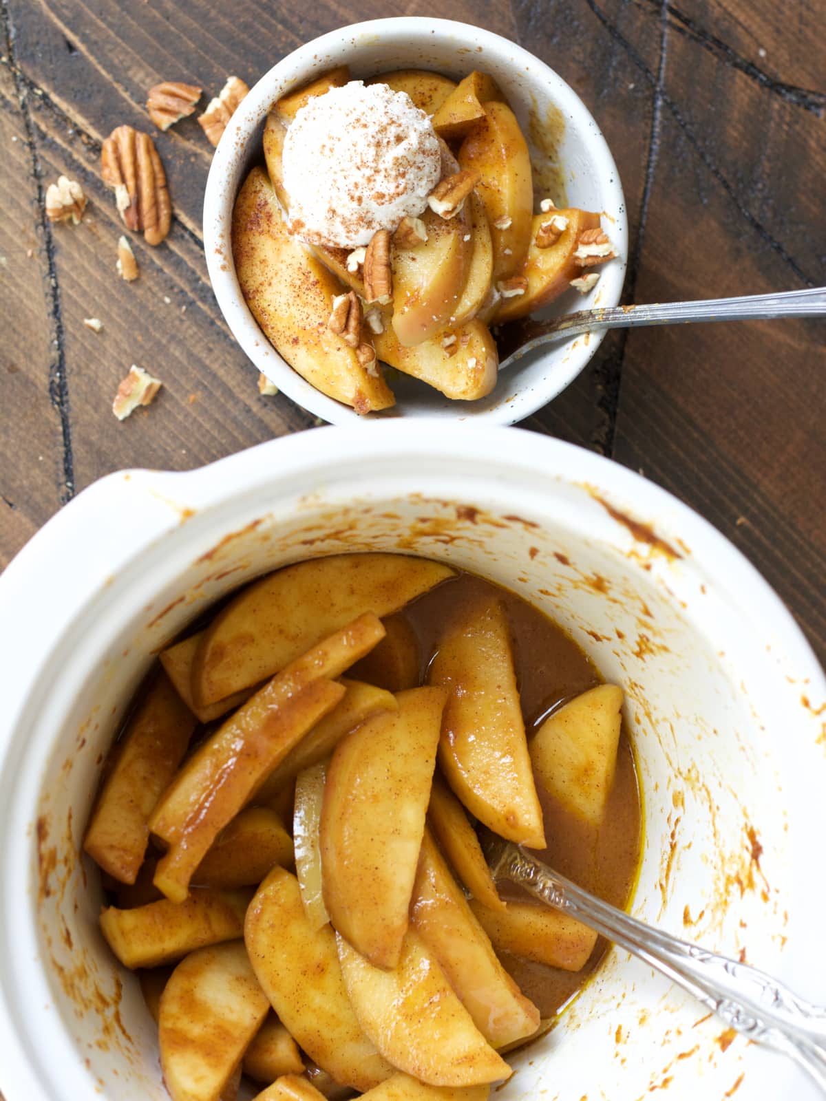 crockpot apples next to a single serving of spiced apples in a white bowl 