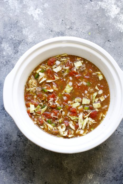 overhead view of black eyed peas and cabbage soup in a slow cooker insert 