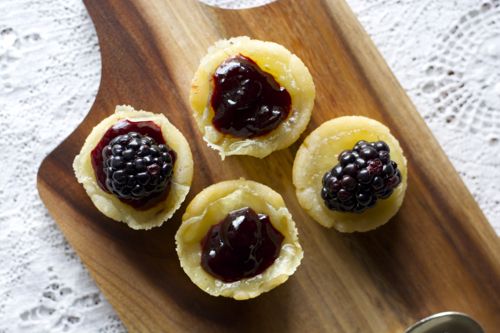 overhead view of four brie bites on a wood board 