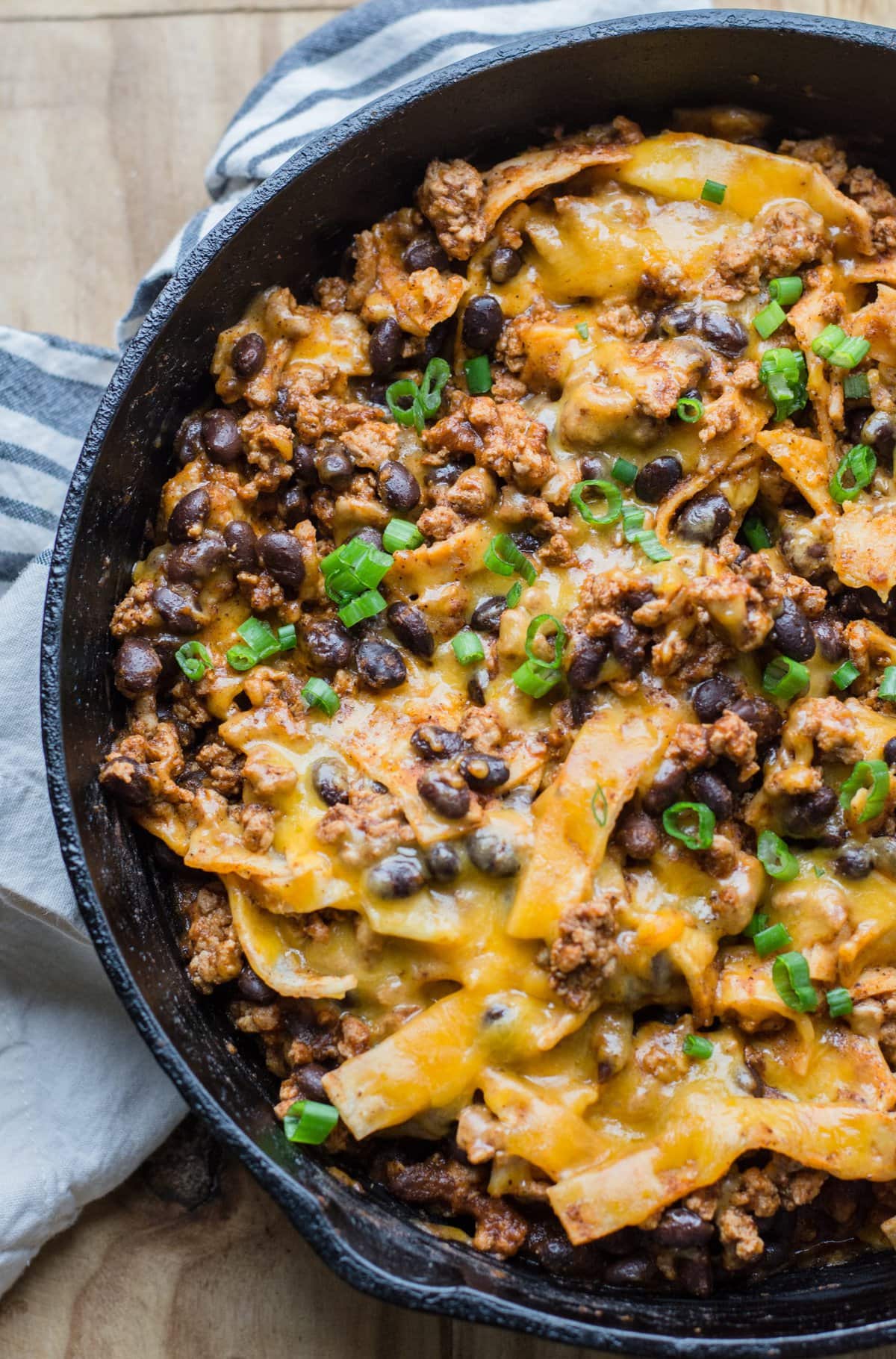 overhead view of ground beef skillet enchiladas with corn tortilla strips 