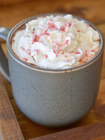a mug full of slow cooker hot chocolate with peppermint mocha flavor and whipped cream on top