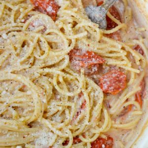 This Garlic Parmesan Pasta is going to become a weeknight favorite! Gluten free pasta is covered in a creamy wine sauce and topped with cherry tomatoes and is ready in only 20 minutes!