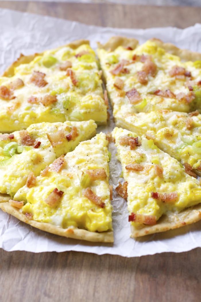 Crispy gluten free crust is topped with scrambled eggs, sautéed leeks, sharp white cheddar and bacon for an easy dinner, or breakfast! 