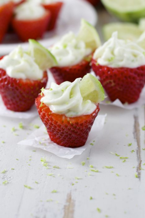 Four key lime stuffed strawberries, seen from the side. 