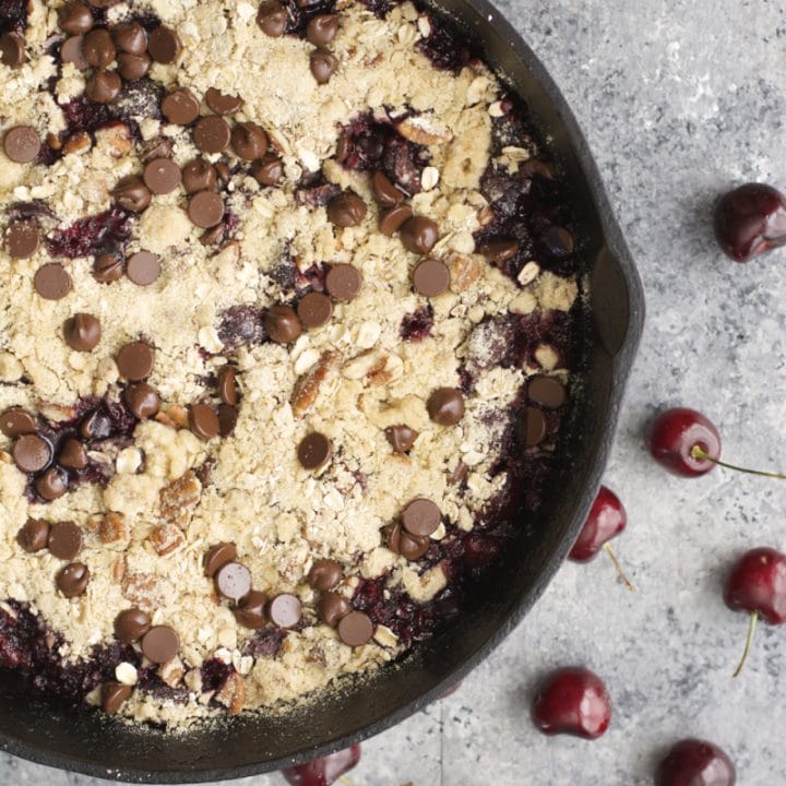 This Chocolate Covered Cherry Crisp is the ultimate Summer treat! Fresh cherries are topped with an chocolate chip oatmeal cookie crumb topping!