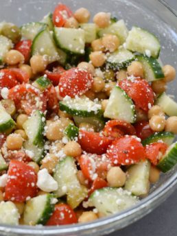 easy chickpea salad mixed with a delicious lemon vinaigrette in a glass mixing bowl