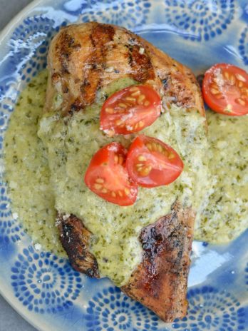 This Chicken with Pesto Cream Sauce is low carb comfort food at it's finest! Grilled Garlic Chicken is smothered with a Creamy Pesto Alfredo sauce making it a decadent keto-friendly dinner!