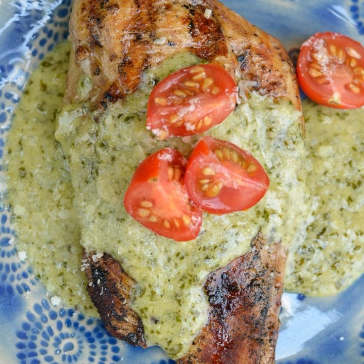 This Chicken with Pesto Cream Sauce is low carb comfort food at it's finest! Grilled Garlic Chicken is smothered with a Creamy Pesto Alfredo sauce making it a decadent keto-friendly dinner!