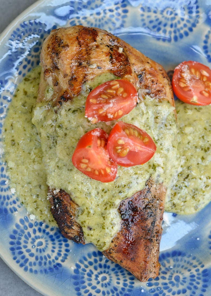 This Chicken with Pesto Cream Sauce is low carb comfort food at it's finest! Grilled Garlic Chicken is smothered with a Creamy Pesto Alfredo sauce making it a decadent keto-friendly dinner!