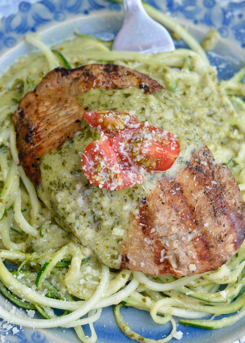 This Chicken with Pesto Cream Sauce is low carb comfort food at it's finest! Grilled Garlic Chicken is smothered with a Creamy Pesto Alfredo sauce making it a decadent keto-friendly dinner!
