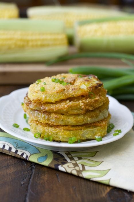 pila de cuatro tomates verdes fritos sureños en un plato blanco