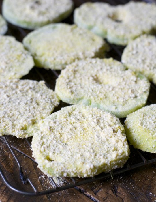  tomates vertes panées sur une grille réfrigérante prêtes à être frites 