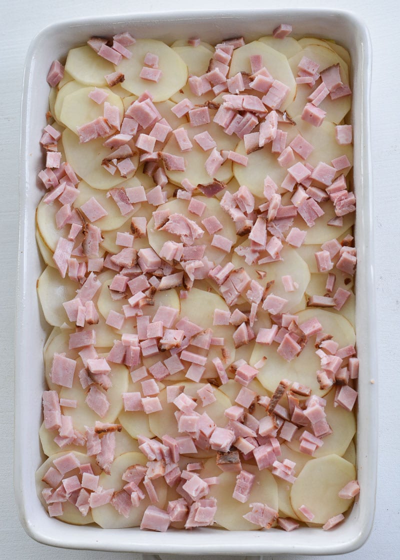 These Cheesy Scalloped Potatoes feature thinly sliced potatoes, a creamy cheddar sauce and chunks of smoked ham!