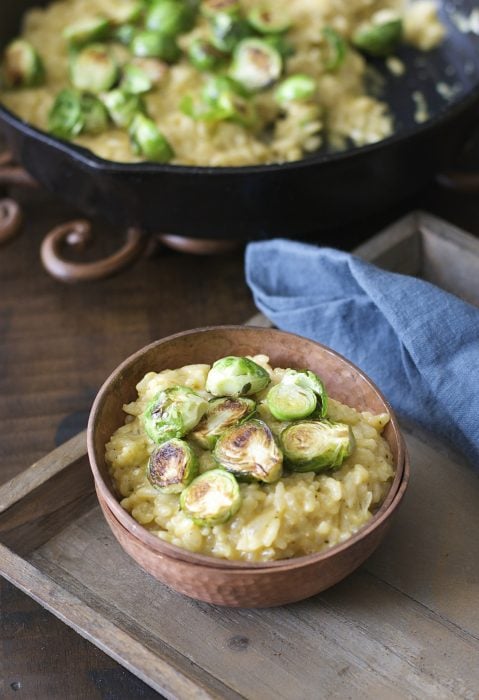 Crispy pan seared Brussels Sprouts are laid atop a bed of creamy Parmesan and white wine risotto! An ultra comforting Winter dish!