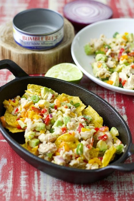 Crispy nachos are topped with fresh avocado, sweet peppers, tuna and lime juice! These healthy and easy Tuna Nachos are the perfect easy weeknight meal!