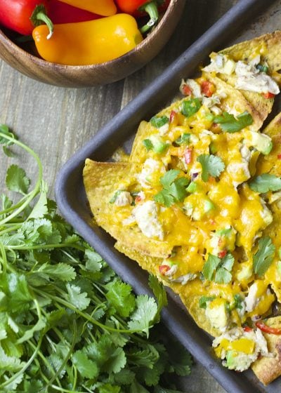 Crispy nachos are topped with fresh avocado, sweet peppers, tuna and lime juice! These healthy and easy Loaded Tex Mex Tuna Nachos are the perfect easy weeknight meal!