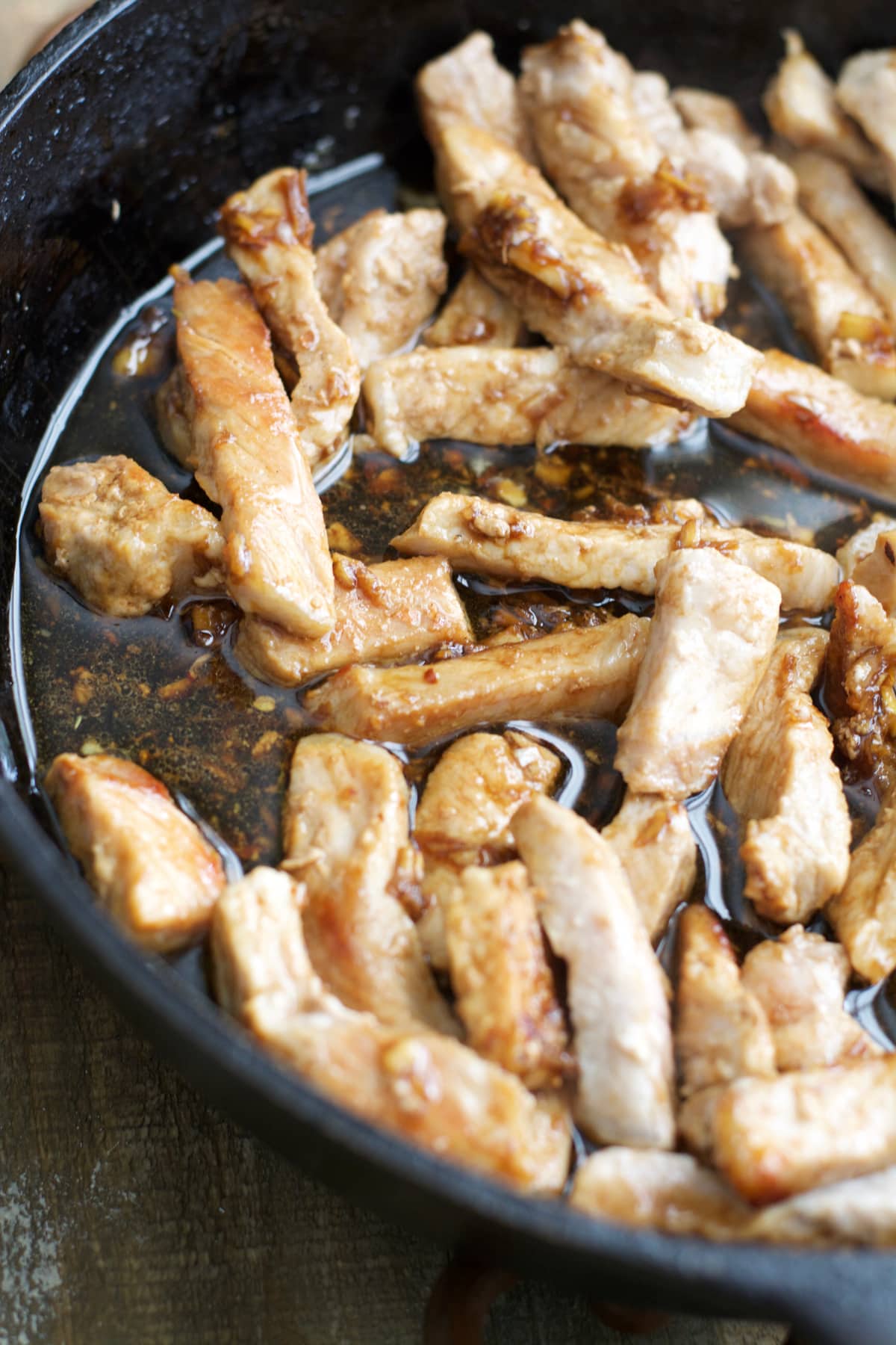 Pork in pork stir fry sauce in a cast iron skillet. 