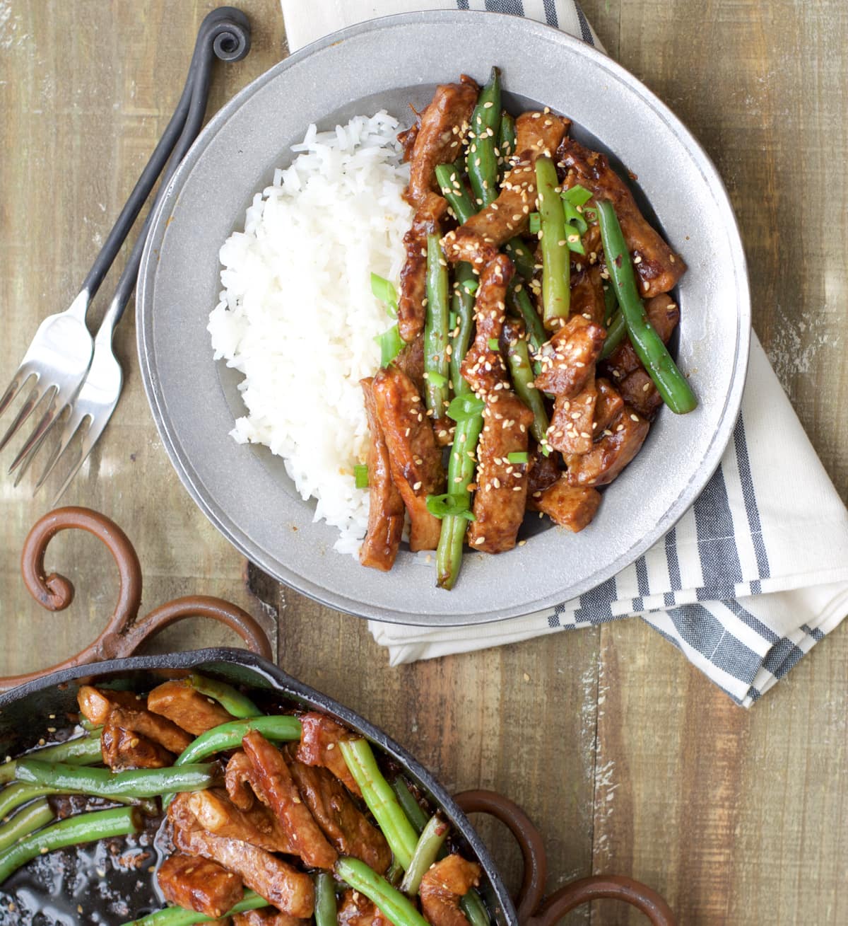 Overhead view of a portion of sesame pork chop stir fry with rice on a plate. 