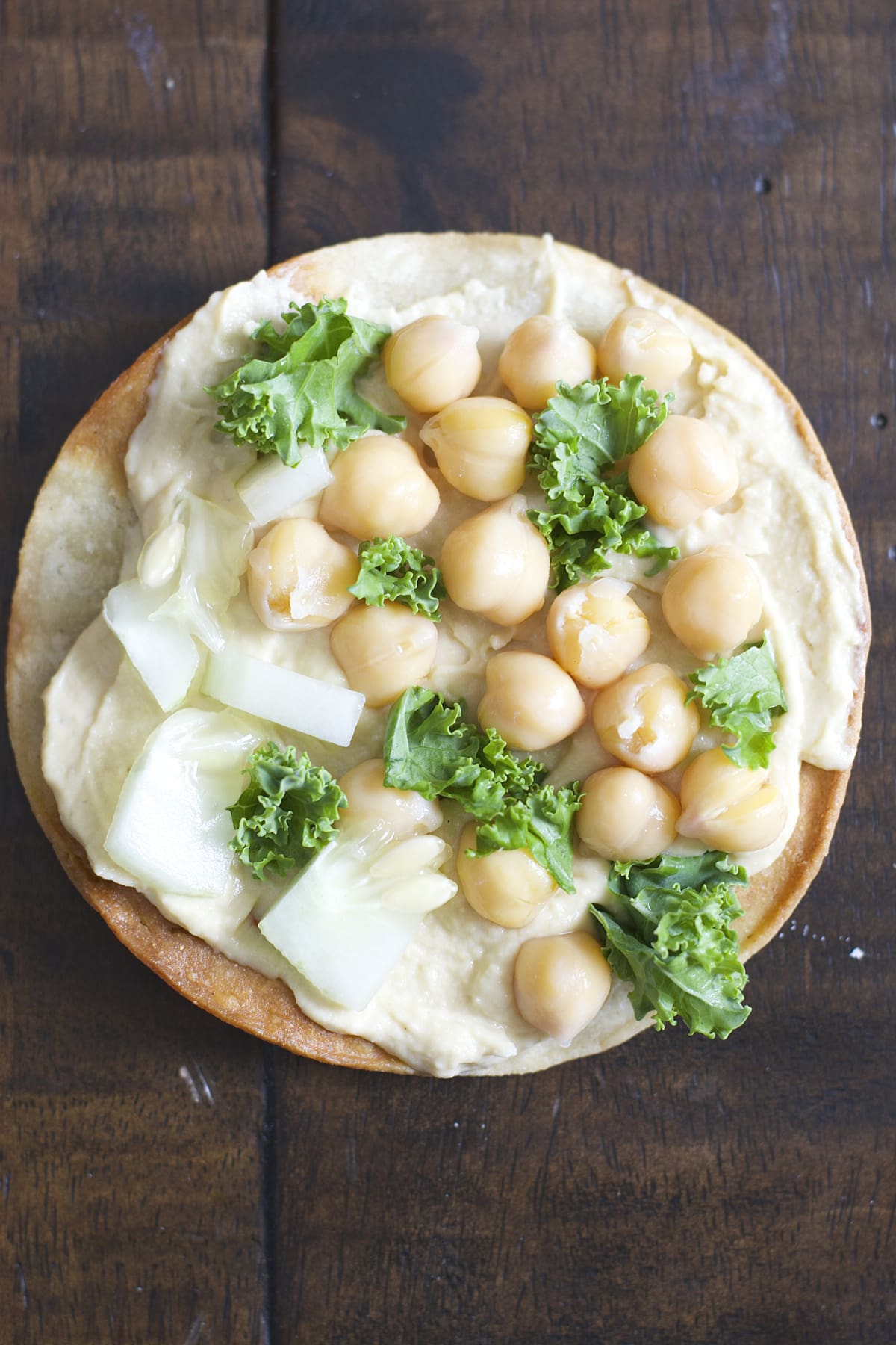 These Mediterranean Hummus Tostadas are an effortless idea for entertaining! Crispy tostadas are topped with creamy hummus, tender chick peas and fresh veggies!