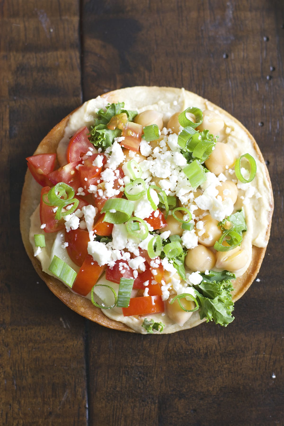 These Mediterranean Hummus Tostadas are an effortless idea for entertaining! Crispy tostadas are topped with creamy hummus, tender chick peas and fresh veggies!