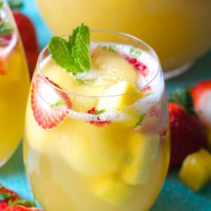 Try this Sparkling Pineapple Strawberry Punch for your next party! Sweet pineapple juice is paired with bubbly ginger ale, fresh fruit and mint for a refreshing non alcoholic punch!