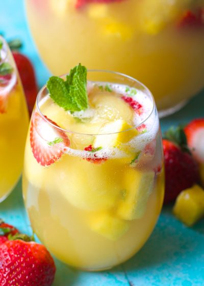 Try this Sparkling Pineapple Strawberry Punch for your next party! Sweet pineapple juice is paired with bubbly ginger ale, fresh fruit and mint for a refreshing non alcoholic punch!