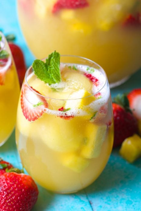 Try this Sparkling Pineapple Strawberry Punch for your next party! Sweet pineapple juice is paired with bubbly ginger ale, fresh fruit and mint for a refreshing non alcoholic punch!