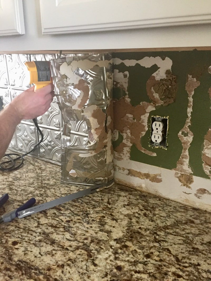 Easily remove a glued on backsplash with our step by step photos and tips! Updated a dated kitchen is easier than you might think, follow along as we remodel our farmhouse!