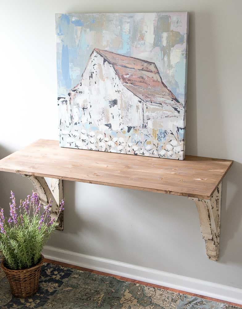 This super easy DIY Corbel Table adds a ton of farmhouse charm to any space! See how you can easily create this look in three simple steps!