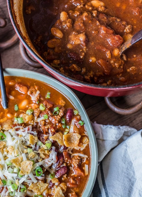 bowl of ground turkey chili topped with Fritos, cheese, and green onions