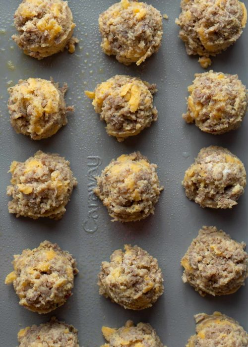 Overhead view of 15 uncooked sausage, egg, and cheese bites on a baking sheet