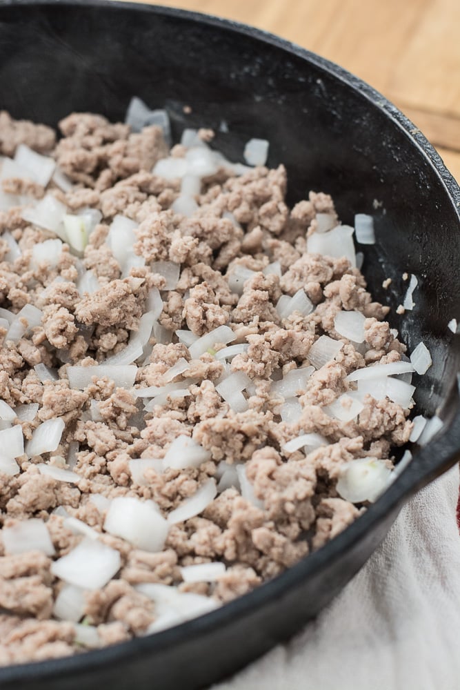 browned ground beef and onion in a cast iron skillet 