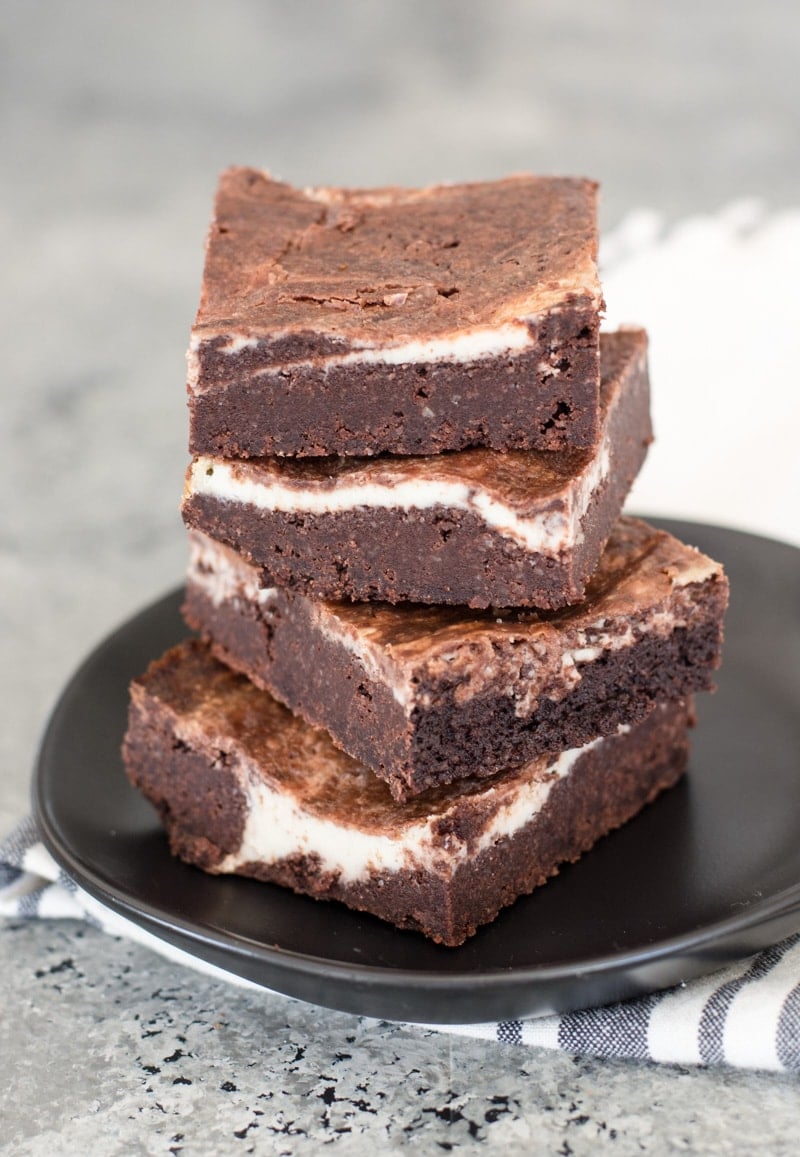 four keto brownies stacked on a gray plate