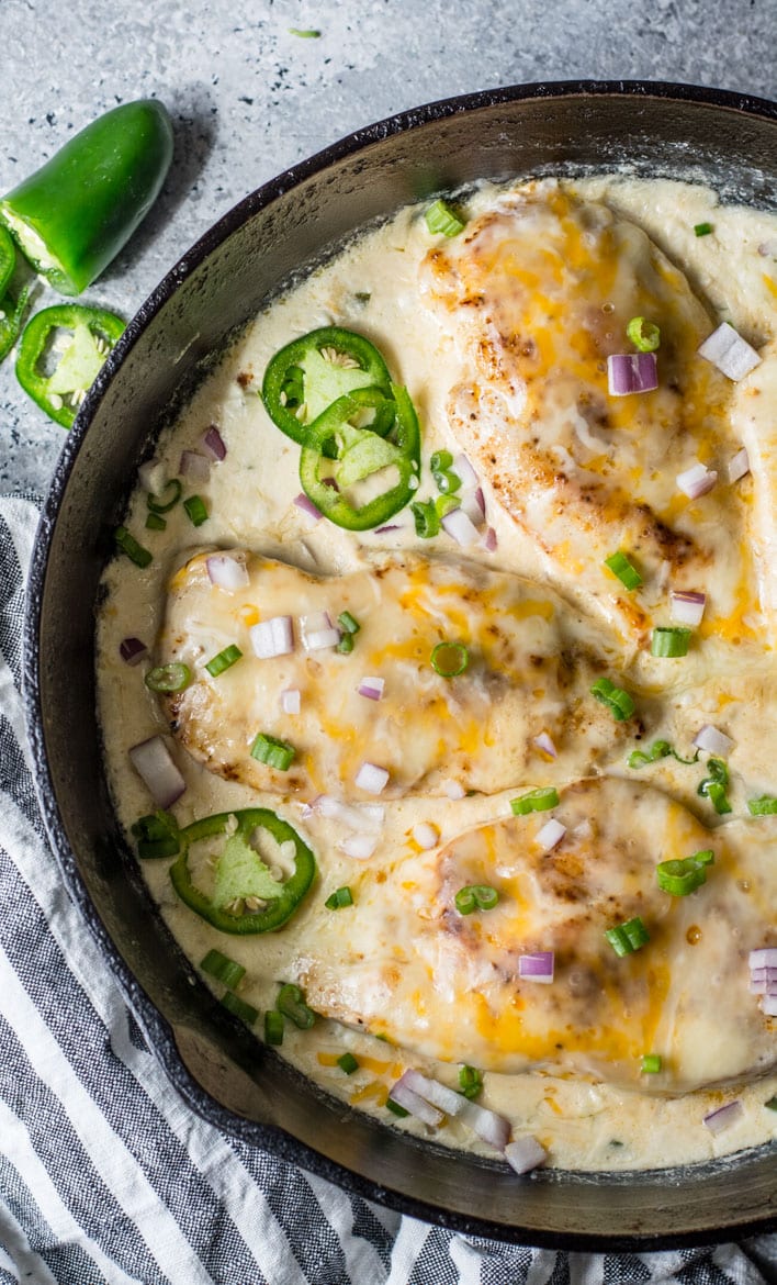 overhead view of three keto chicken breasts in a cast iron skillet 