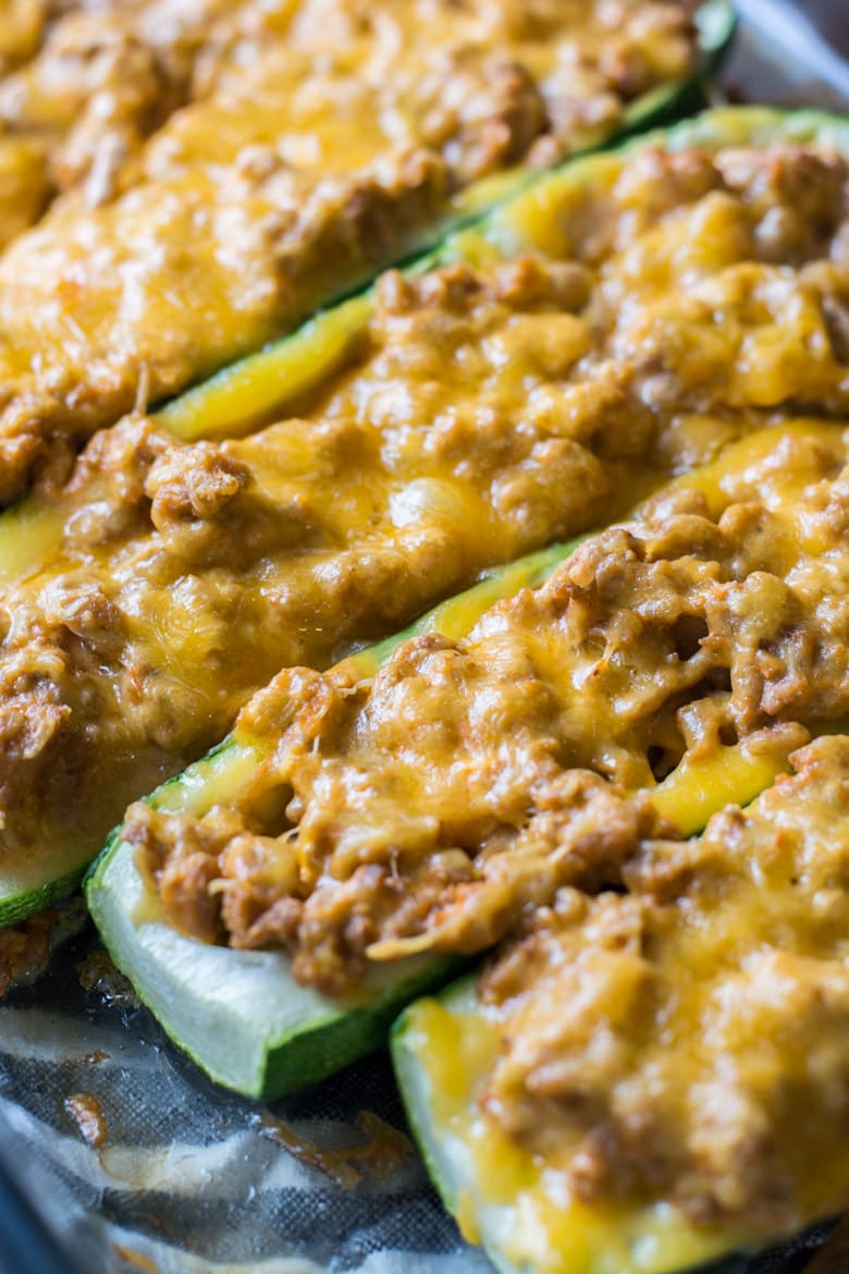 several cheeseburger zucchini boats in a baking dish coated in melted cheese