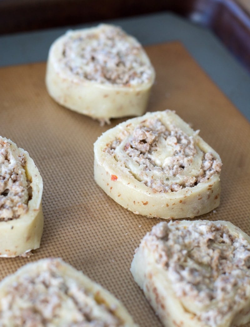 unbaked sausage cream cheese pinwheels on a baking sheet 