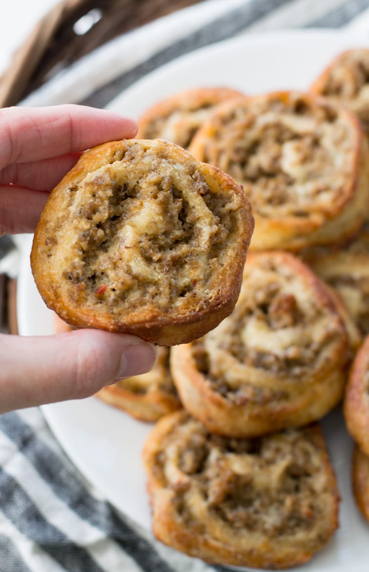 a keto sausage cream cheese pinwheel being held aloft 